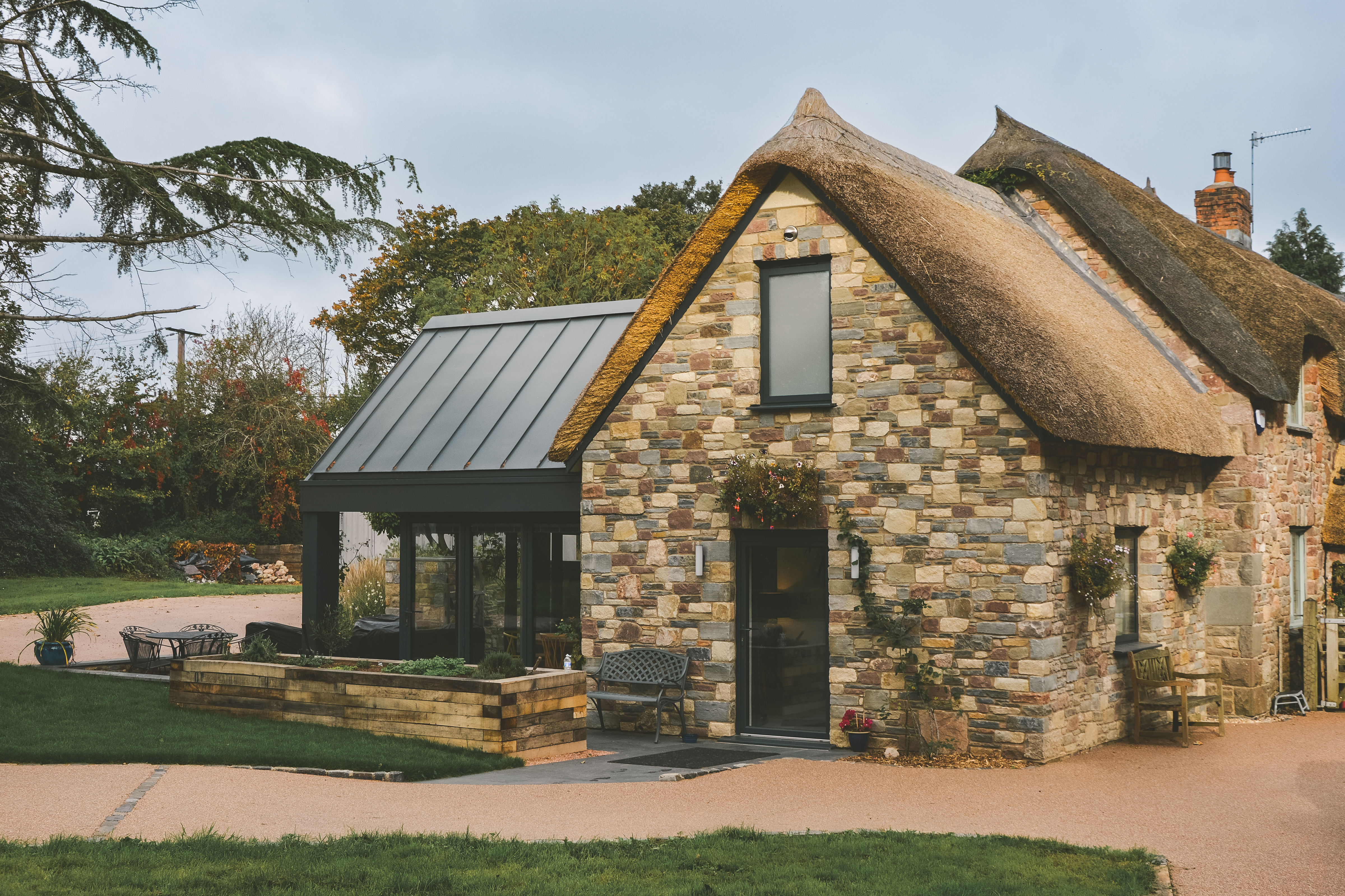 Angus Design Limited — Modern thatched-roof extension on a Grade II listed cottage in Portbury, Bristol, designed by Angus Design Ltd."