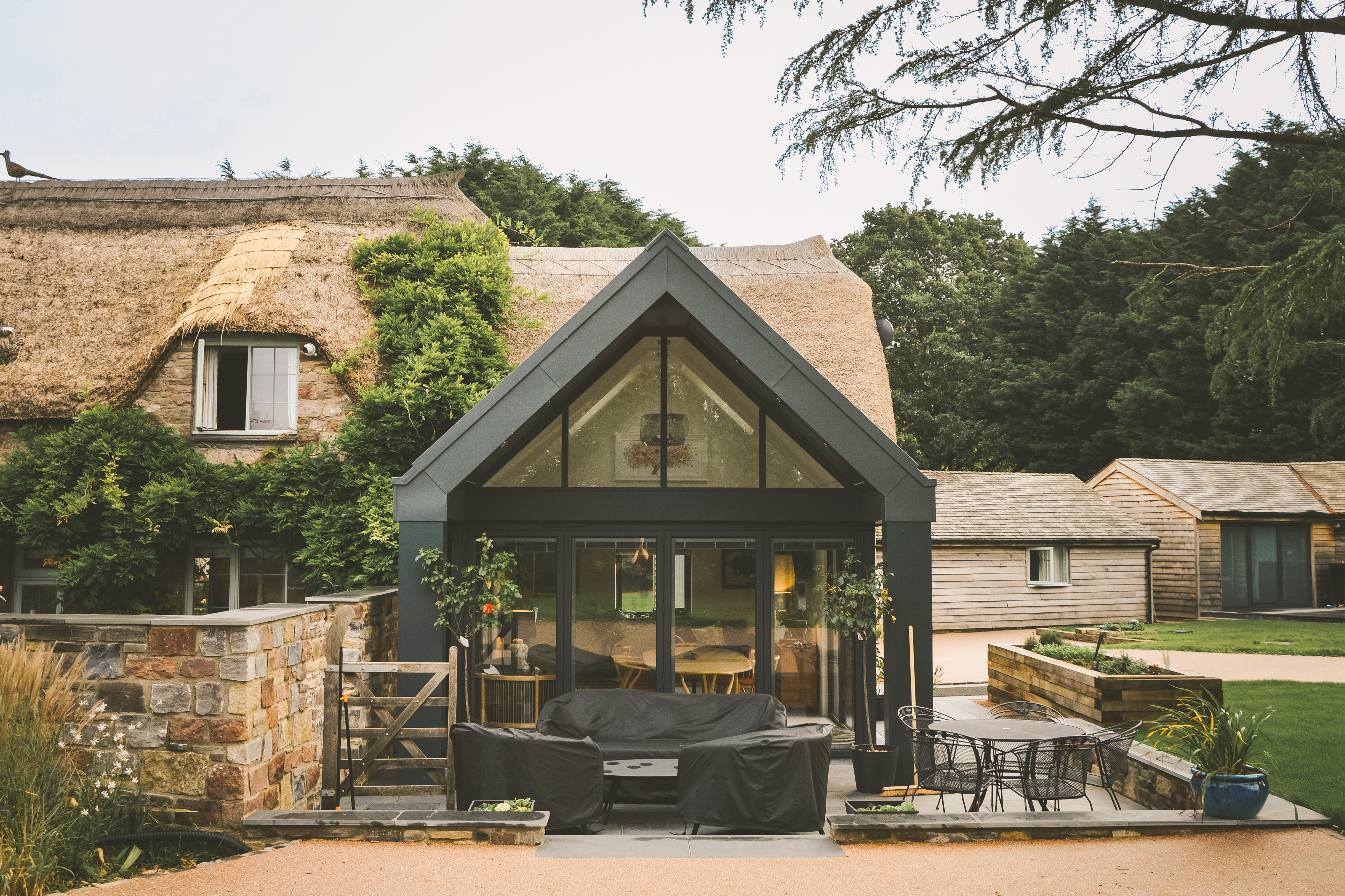 Angus Design Limited — Modern thatched-roof extension on a Grade II listed cottage in Portbury, Bristol, designed by Angus Design Ltd."