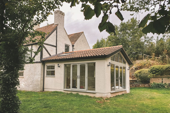 Hambrook side and rear extension under permitted development and green belt policy, featuring vaulted ceiling, gable glazing, stylish kitchen, garage conversion, and garden room