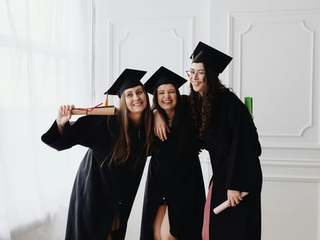 Three happy graduates with diplomas