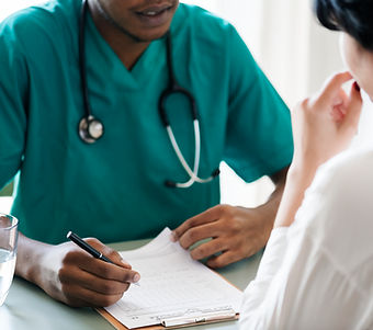Doctor Reviewing Patient Symptoms During Health Insurance Consultation