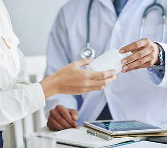 Doctor Handing Prescription Medication To Patient During Health Insurance Covered Visit