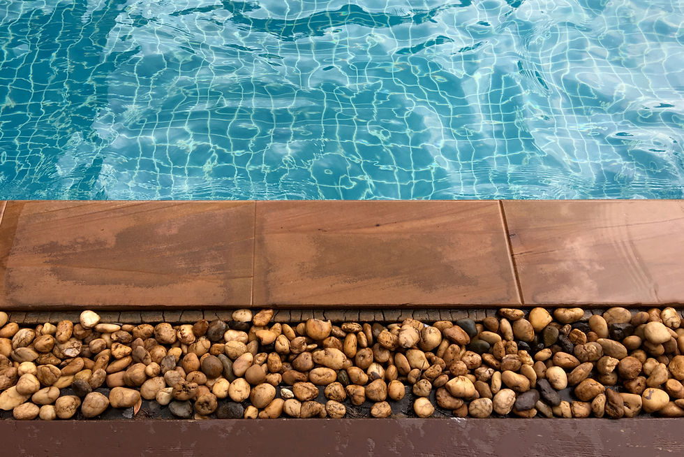 Modern Swimming Pool With Contemporary Surface Finish, Clear Blue Water, And Decorative Stone Border Around The Pool Edge