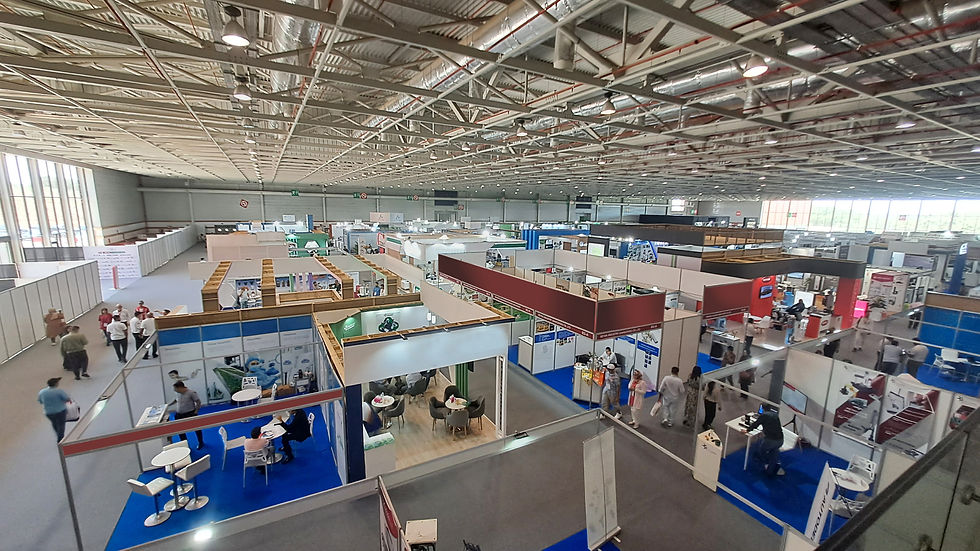 Large Indoor Trade Show Venue With Multiple Exhibition Booths And Business Visitors