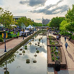 Lively Scene At Carroll Creek Park Frederick Maryland Featuring Canal Pedestrians And Building In Distance