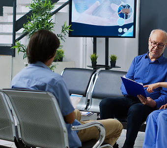Healthcare Professional Reviewing Health Insurance Documents With Patient In Waiting Area