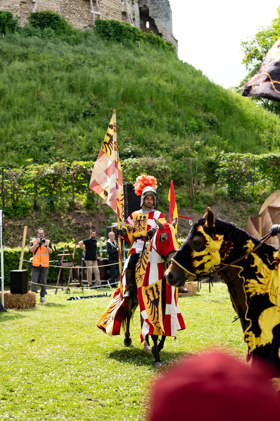 Chevalier à cheval portant les couleurs rouge et jaune lors d'une parade de fête médiévale