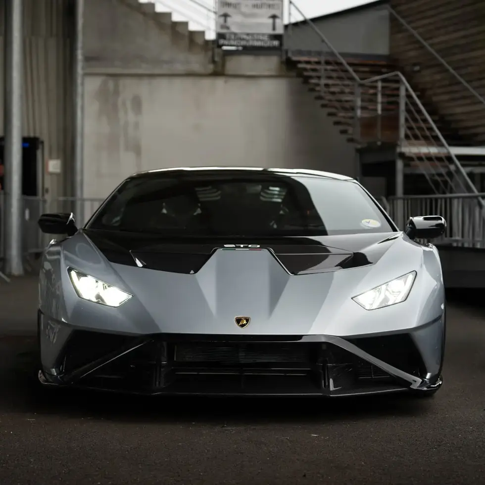 Face avant d'une Lamborghini Huracán STO grise et noire avec phares allumés lors d'un rass