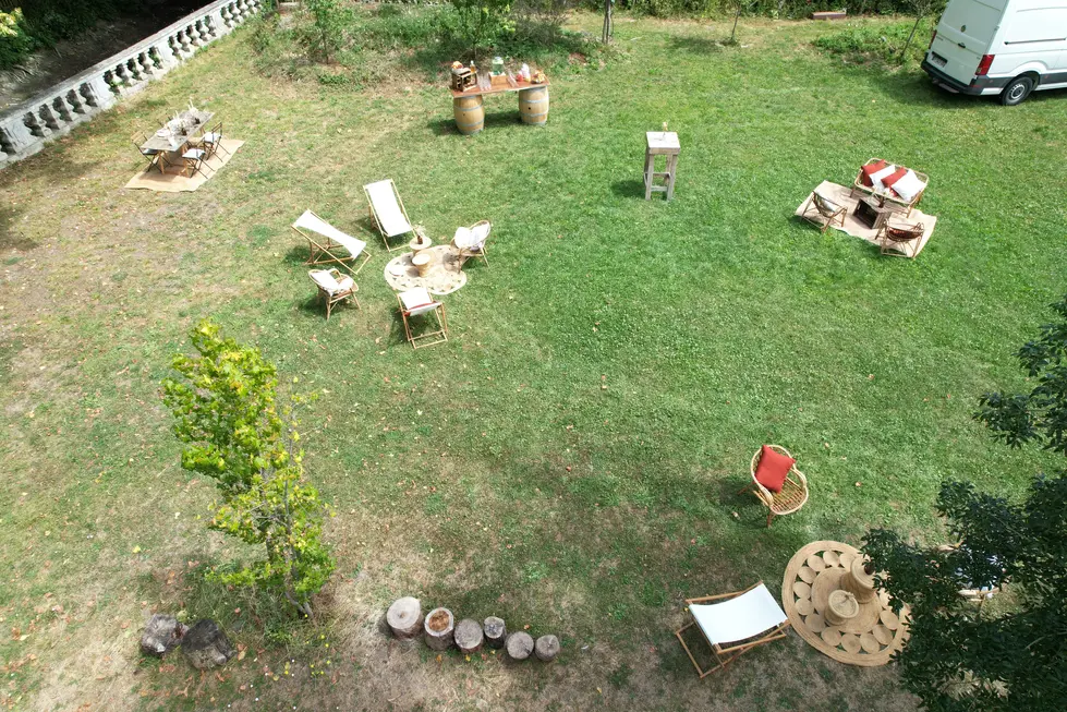 Vue aérienne d'un grand jardin de réception avec mobilier champêtre, salons de jardin en r