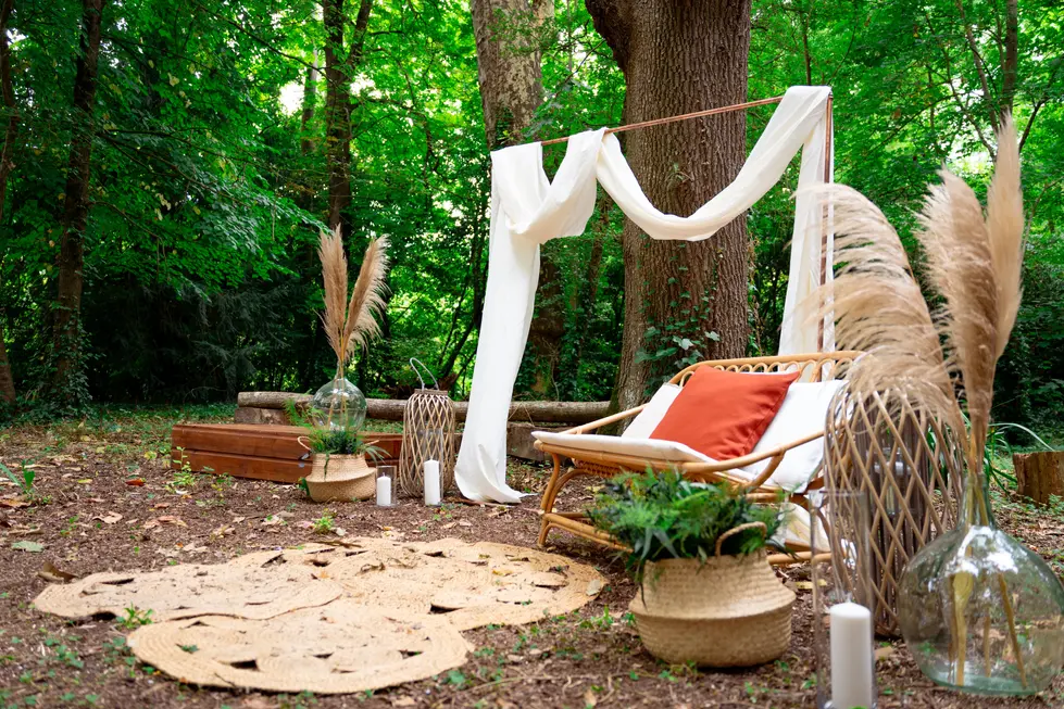 Aménagement d'une cérémonie de mariage champêtre en plein air sous les arbres avec mobilie