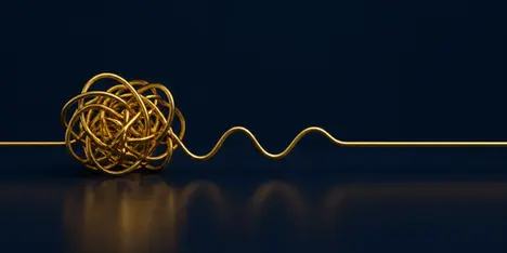 A gold wire from a messy tangled knot to a straight line, for a post on non-stimulant ADHD medication.