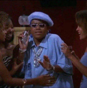 Lil' Romeo surrounded by women, wearing sunglasses, holding a phone