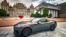 2025 Mustang GT patrol vehicle photographed at the Empire State Plaza in Albany, in front of the iconic I Love NY sign, with the State Capitol as a backdrop.