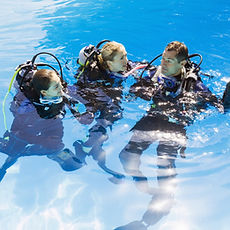 three divers having fun on the water