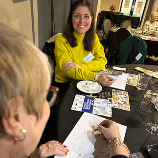 Carol Hanon from BEC drawing another guests portrait as they laugh watching her in action