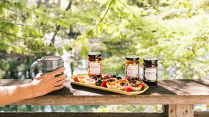 Jars and waffles on a wooden table outdoors.