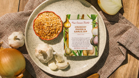 Plate with crunchy onion dip and garlic cloves.