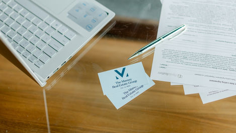 Business cards on a desk with a pen.