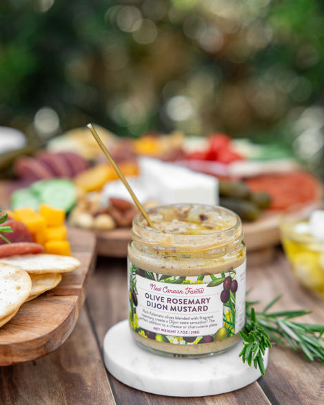 Jar of olive rosemary Dijon mustard on table.