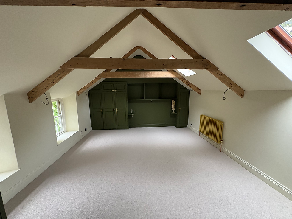 Renovated attic room with exposed beams and built-in cabinets