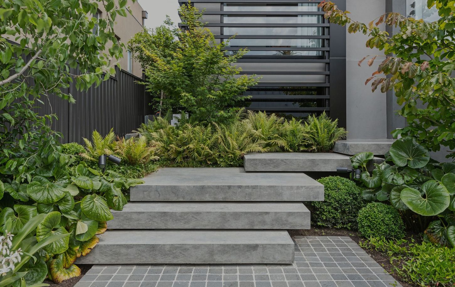 Image of concrete floating steps with a lush green garden bed around it. Antares Court, Aberfeldie.