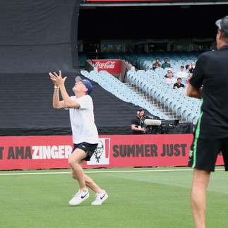 One Catch Max online community member running on the grass of the MCG with their arms lifted as a cricket soars above.