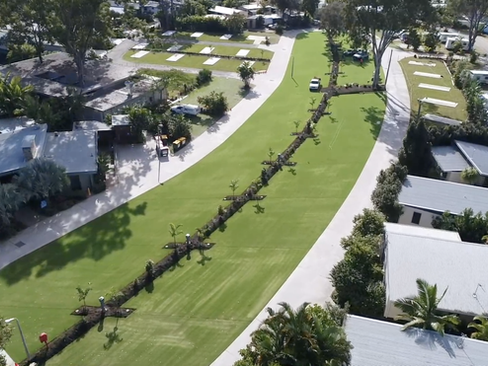 Drone view of lush synthetic grass and trees at Big 4 Caravan Park Helensvale, surrounded by caravan bays and pathways.