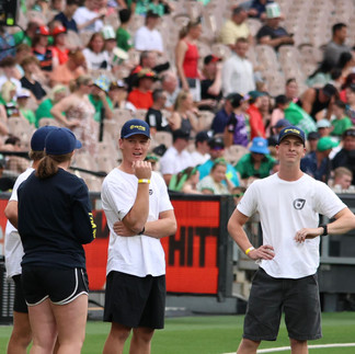 Four Catch Max online community members huddled in a group on the sidelines of the MCG.