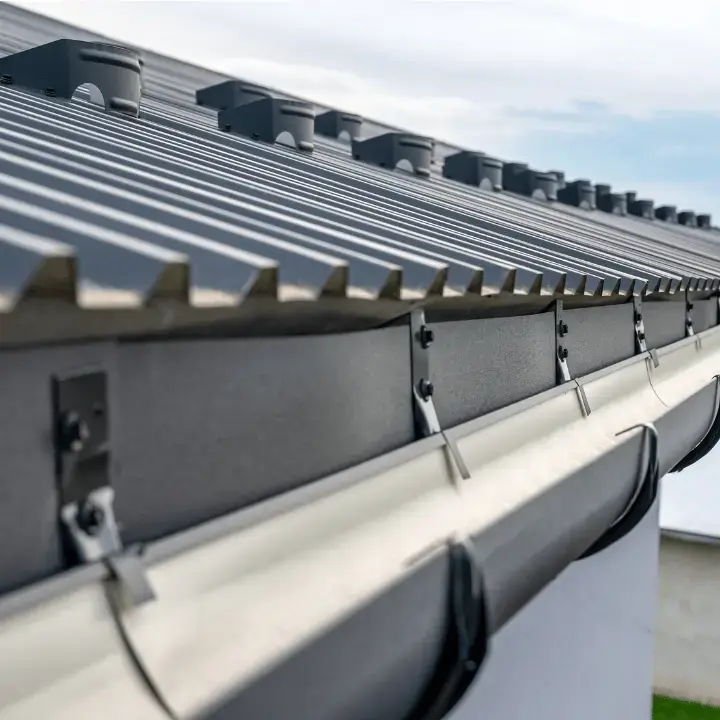 Close-up of seamless gutter system installed on a modern metal roof in Redmond, Oregon