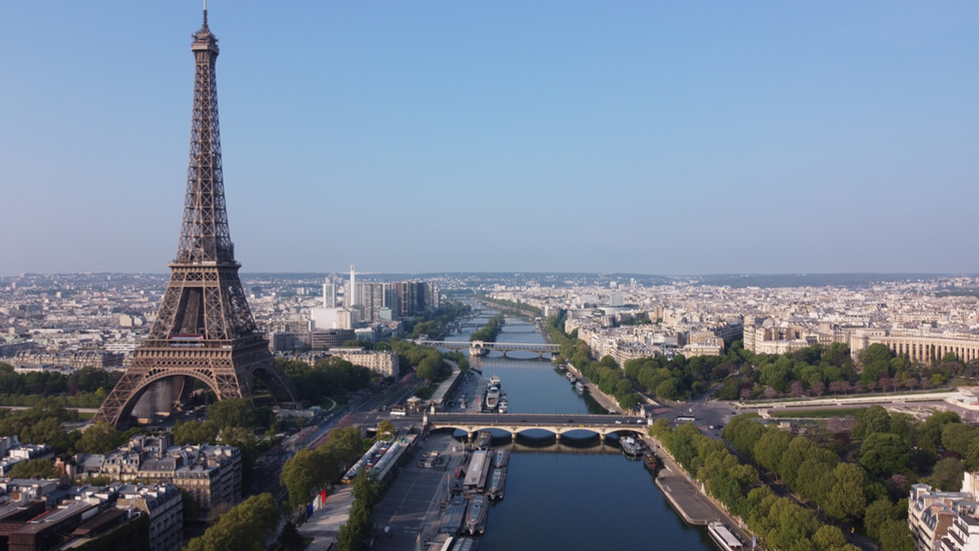 View of the Eiffel Tower in Paris overlooking the Seine River with bridges and cityscape in the background, capturing the vibrant urban beauty and architectural elegance reminiscent of Cristian Mitrani's artistic focus on capturing iconic cityscapes and cultural landmarks.