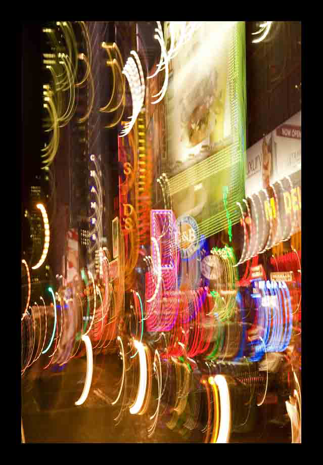 Abstract long-exposure shot of Times Square’s neon lights in motion, creating swirling patterns of color — an energetic cityscape by Cristian Mitrani.