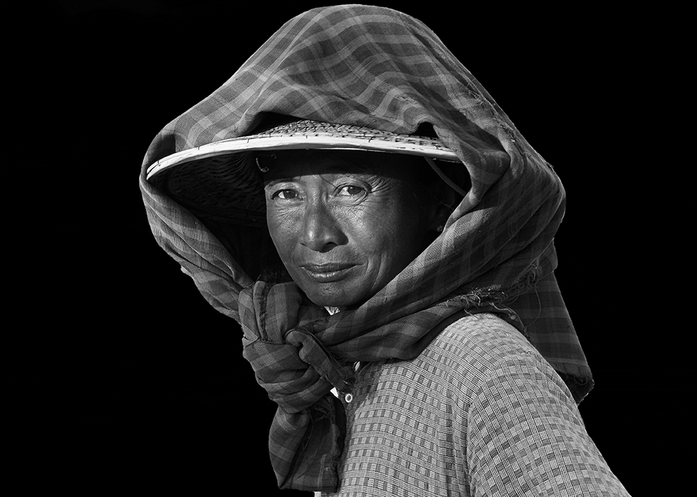Black and white portrait of a person wearing a hooded garment, their gaze direct and expressive — a striking cultural capture by Cristian Mitrani.