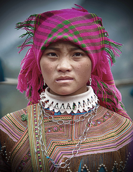 Portrait of a young woman adorned in vibrant traditional attire and intricate jewelry, gazing confidently — a rich cultural capture by Cristian Mitrani.