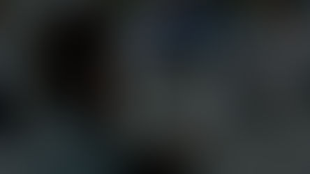 Video thumbnail with play button overlay showing a person from behind in a blurred office or workspace setting.