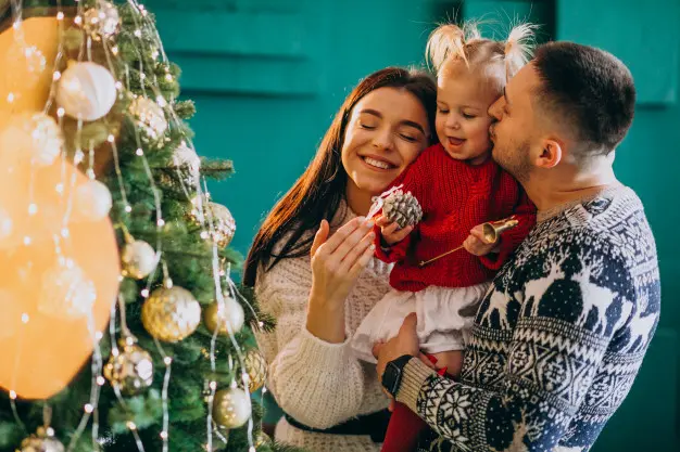 family-with-little-daughter-hanging-toys-christmas-tree.jpg.webp