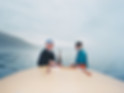 Two men standing on the aft deck of a cabin cruiser, with calm water on the lake.