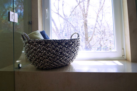 Silver Wicker basket with towels on window sill