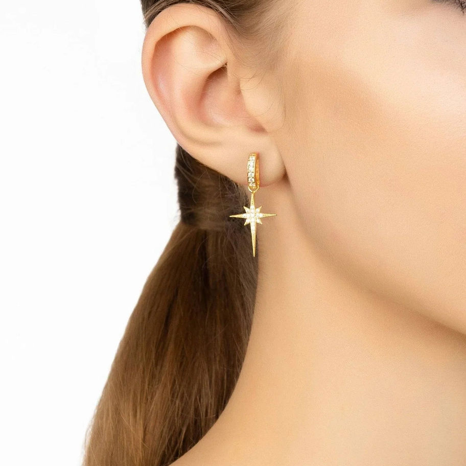 Boucle d'oreille étoile dorée scintillante sur une femme, Maison Argÿel.