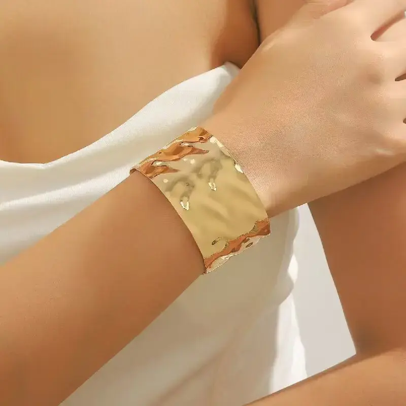 Gros bracelet doré porté sur un poignet, Maison Argÿel, bijou pour femme.