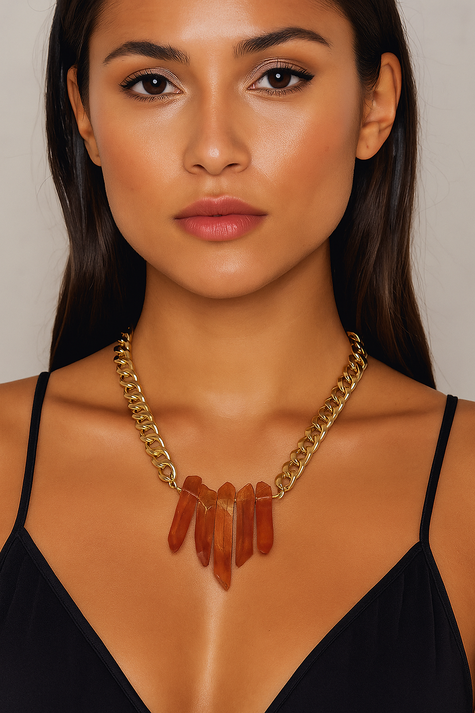 Femme portant un collier doré avec des pierres orange ; Maison Argÿel.