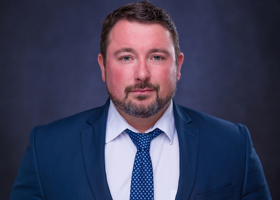 Professional portrait of Jacob Watters from NCADD, wearing a blue suit, white shirt, and patterned tie.
