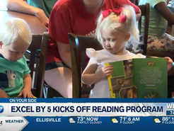 a boy and girl sitting in chairs and reading books