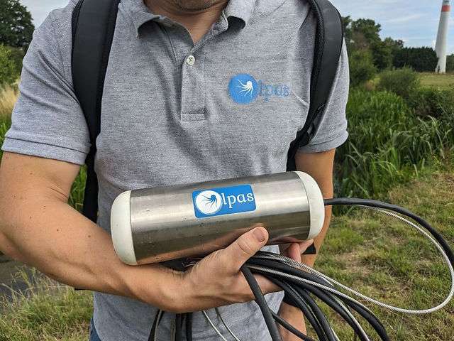 Kristof (Olpas) holding the Olpas Watermonitoring sensor in his arms like a baby 