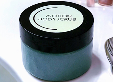 Motion Moisturizing Body Scrub displayed on bathroom countertop.