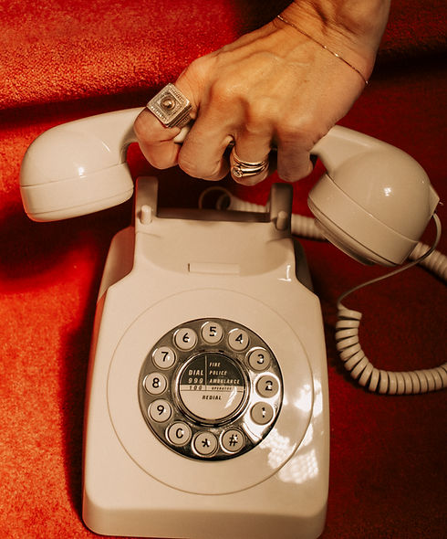Close-up of a hand picking up a vintage rotary phone, symbolizing reaching out for burnout recovery support.