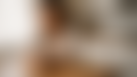 אישה יושבת לבדה ליד שולחן מטבח בשעות הבוקר המוקדמות, מביטה בטלפון ללא הודעה – ביטוי לשתיקה כעונש ולאובדן חברות קרובה.