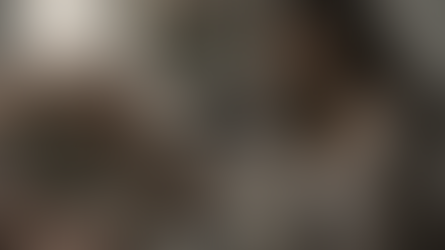 אישה צעירה יושבת לבד מוקפת זרי ורדים ומתנות, מבט מהורהר לצד טלפון עם הודעות רבות - הפצצת אהבה ו-Love Bombing באווירה מלנכולית.