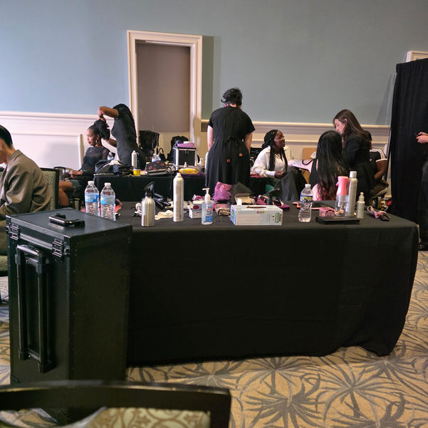 CCI students working on hair services backstage at a professional event