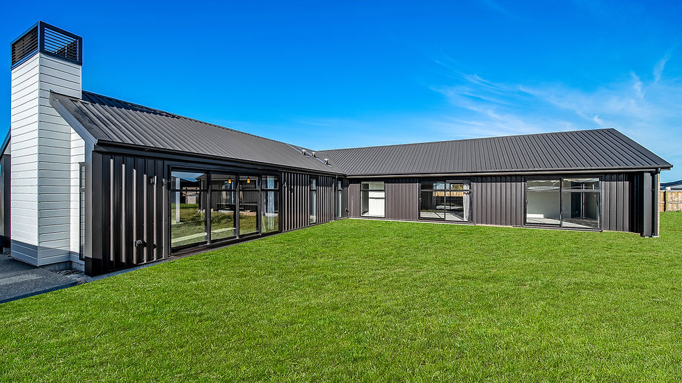 Modern black cladding exterior home with large windows and a private green lawn built by Hedgley Corporation.