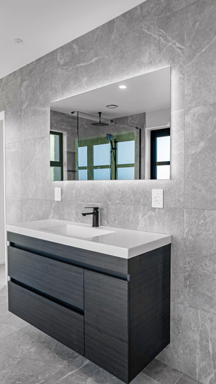 Modern bathroom design by Kian Clements-Ormond showcasing sleek vanity and grey tile finishes.